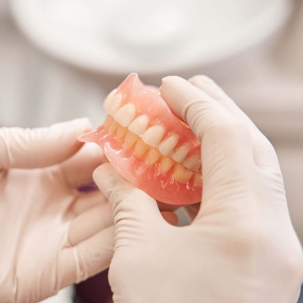 Dentist demonstrating dentures at Elite Dental & Wellness in Mesa, AZ