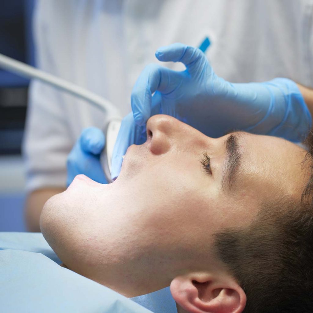 Man receiving a dental exam at Elite Dental & Wellness in Mesa, AZ