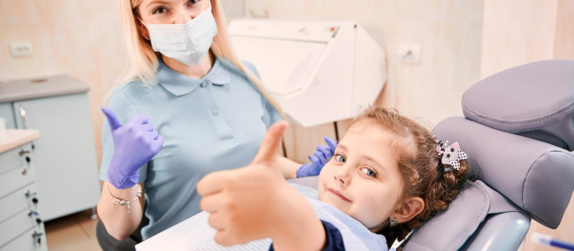 female-dentist-cute-little-girl-giving-thumbs-up